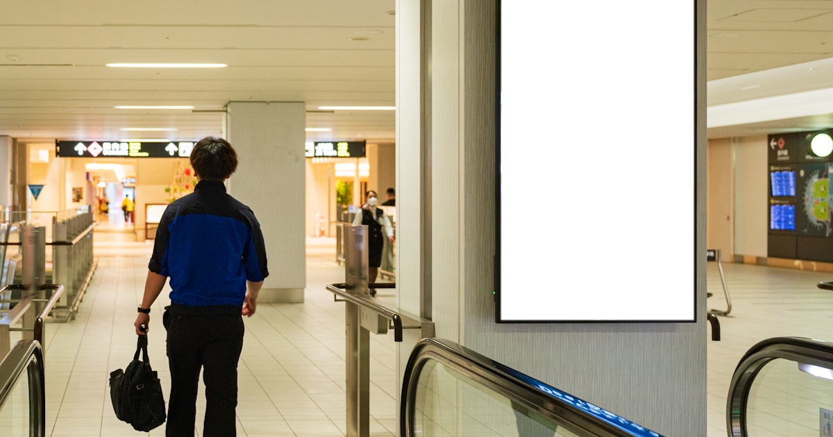 a man walking down an escalator carrying a bag