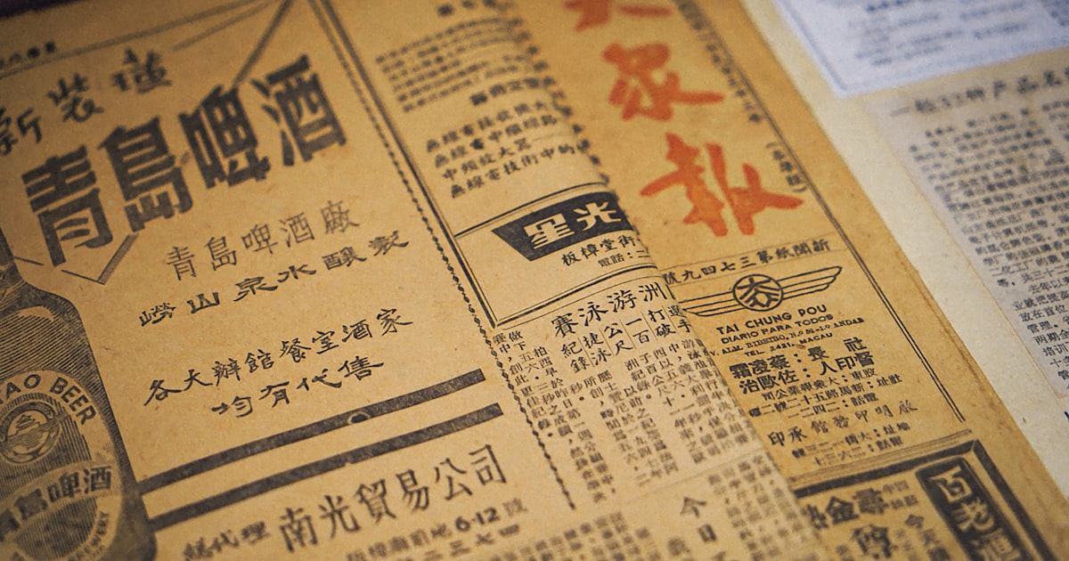 Close-up of an old chinese newspaper with text and ads.