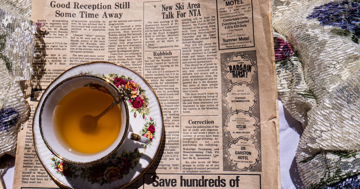 a cup of tea sitting on top of a newspaper
