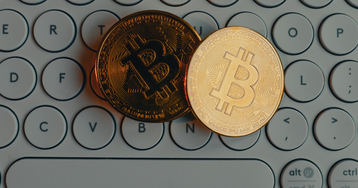 a bit coin sitting on top of a computer keyboard