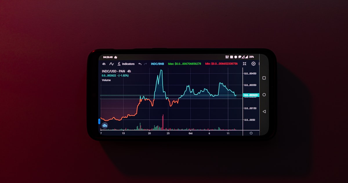 a cell phone displaying a stock chart on a red background