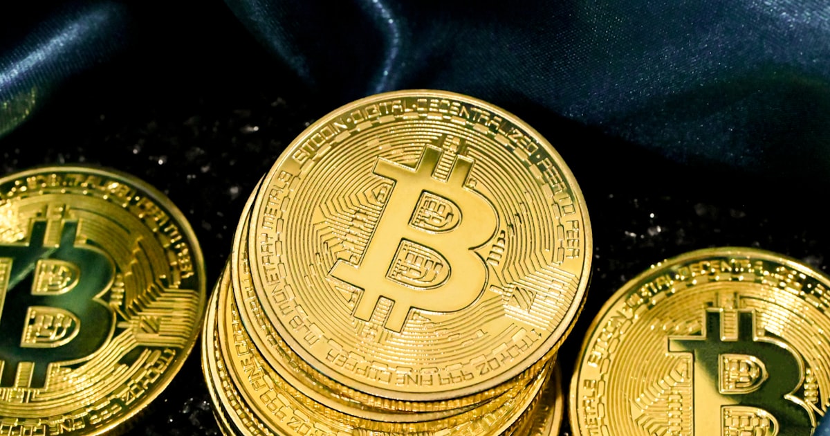 a pile of gold bitcoins sitting on top of a black cloth