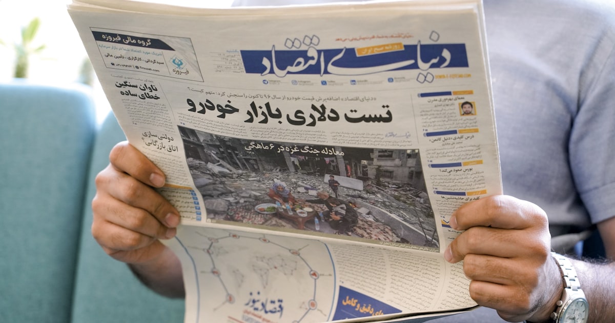 a man holding a newspaper with a picture of a man on it