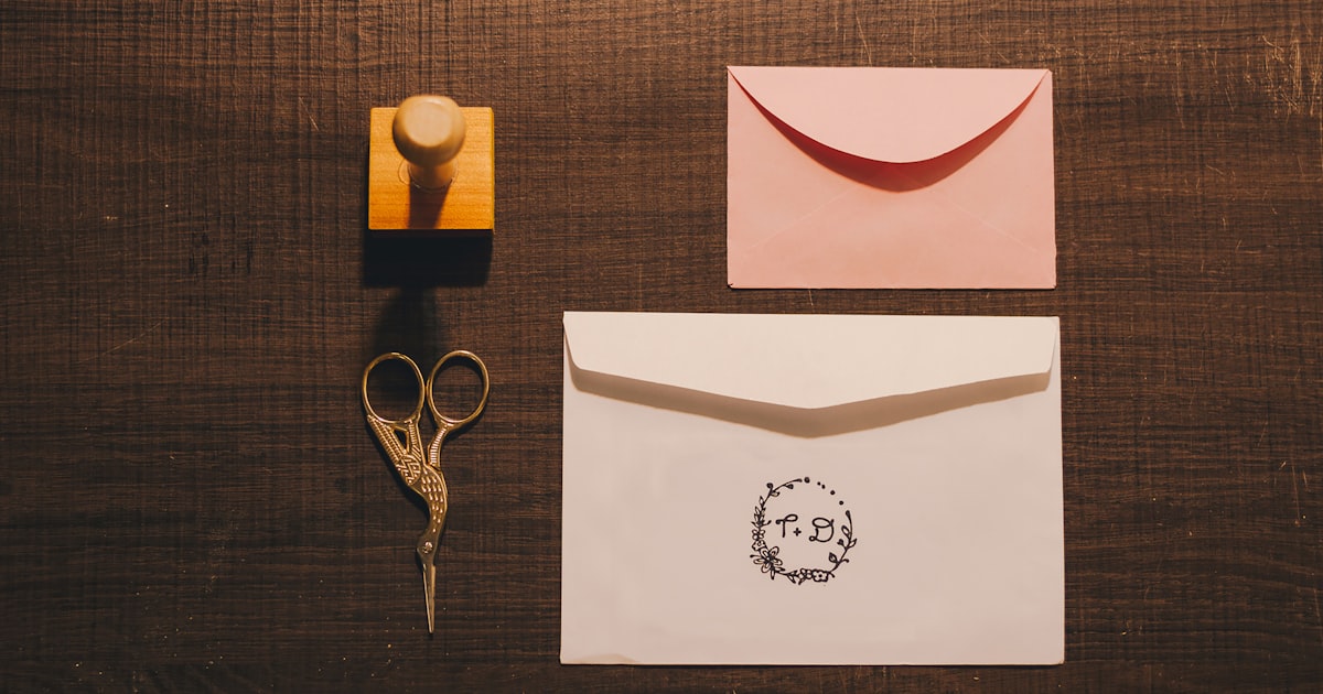 a pair of scissors, a rubber stamp, and a card on a table