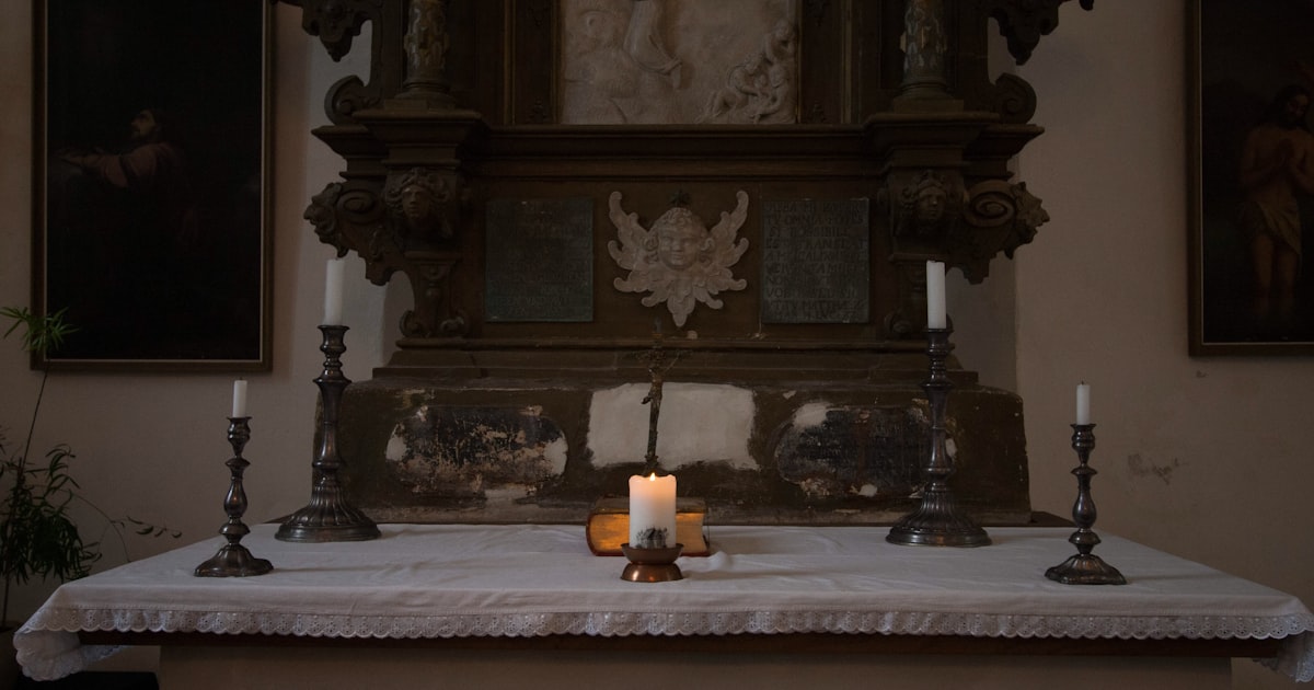 a lit candle on a table in a church