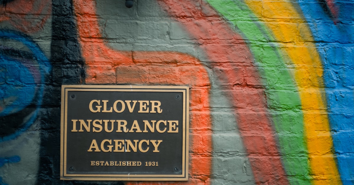 a sign on a brick wall that says glover insurance agency