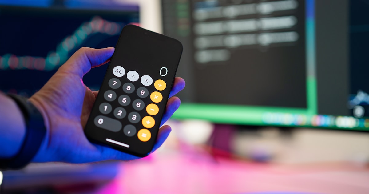 a person holding a remote control in front of a computer