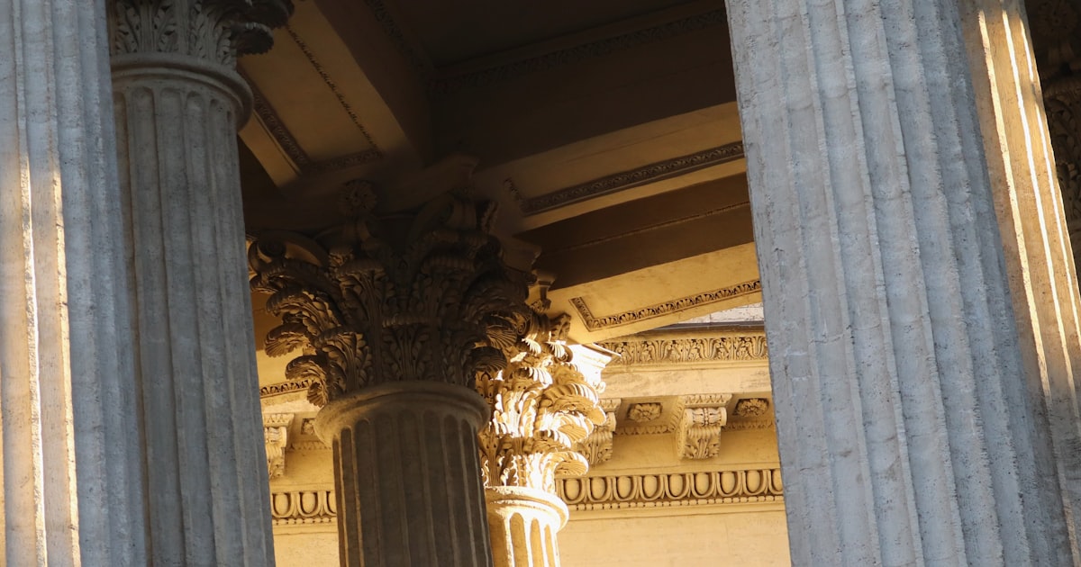 the columns of a building with a clock on each of them