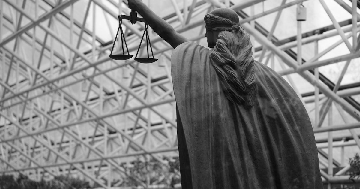 Statue of lady justice holding scales indoors