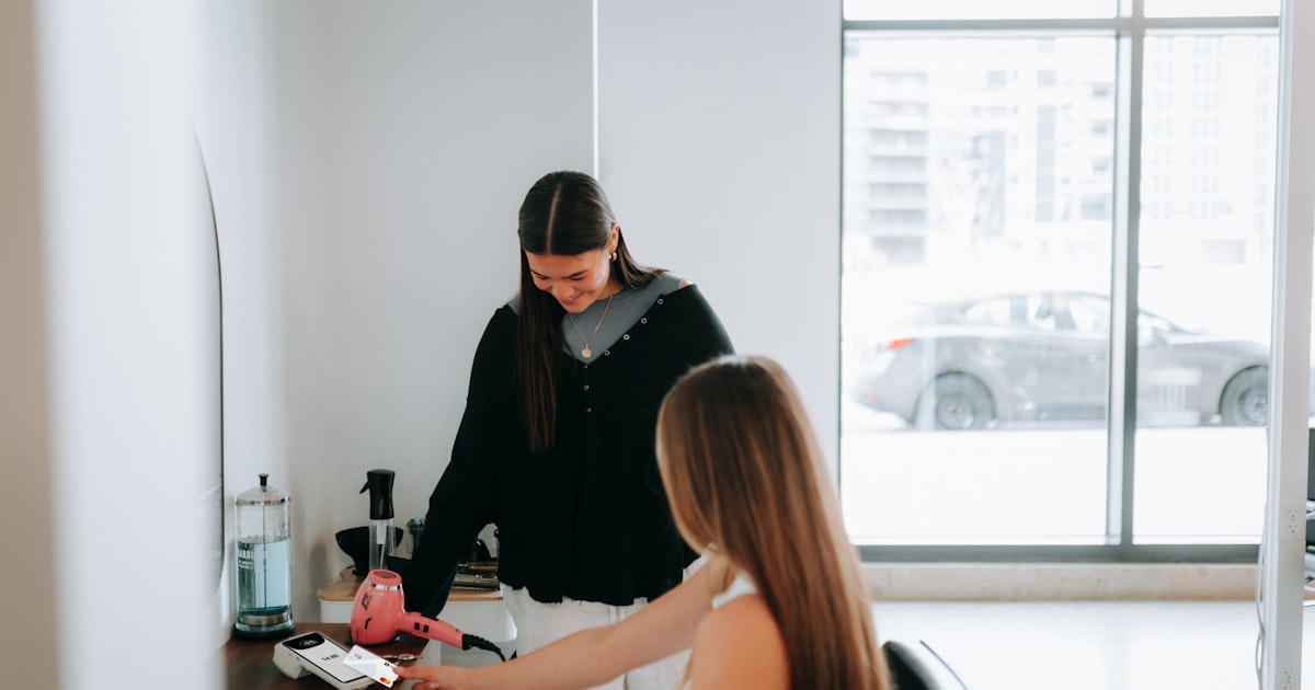 A hairstylist is working on a customer's hair.