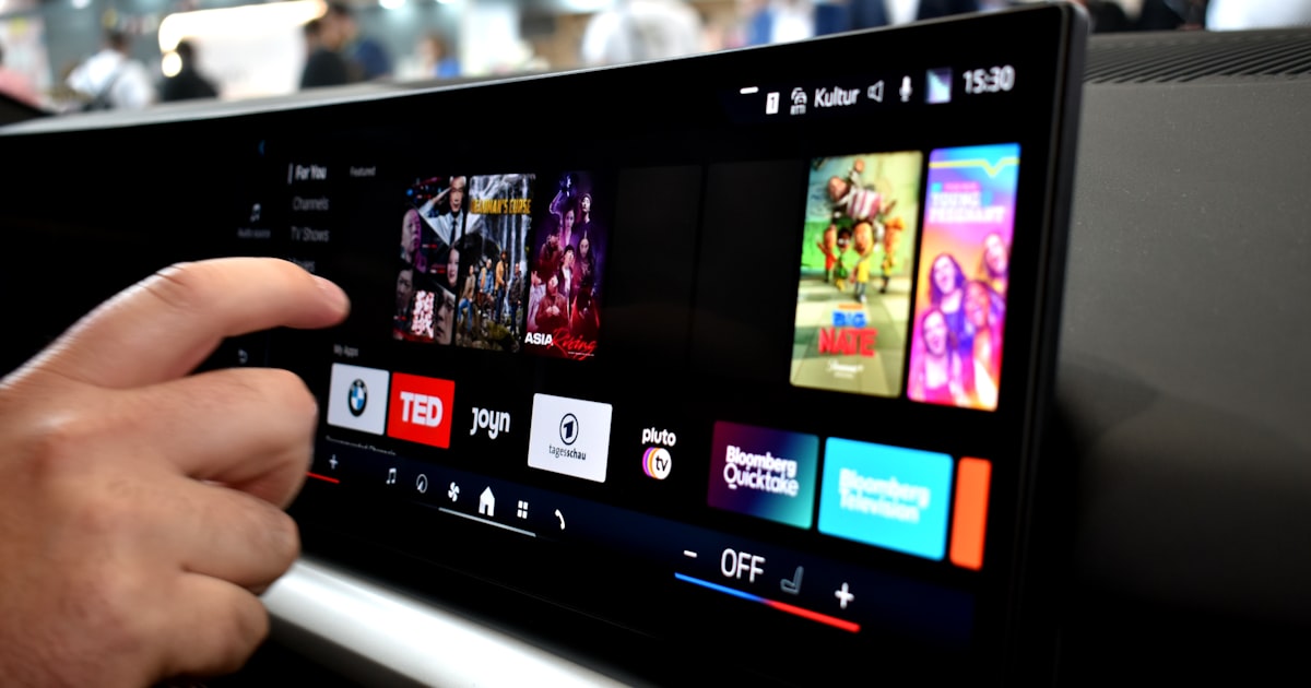 Person touching a car infotainment screen with media options.