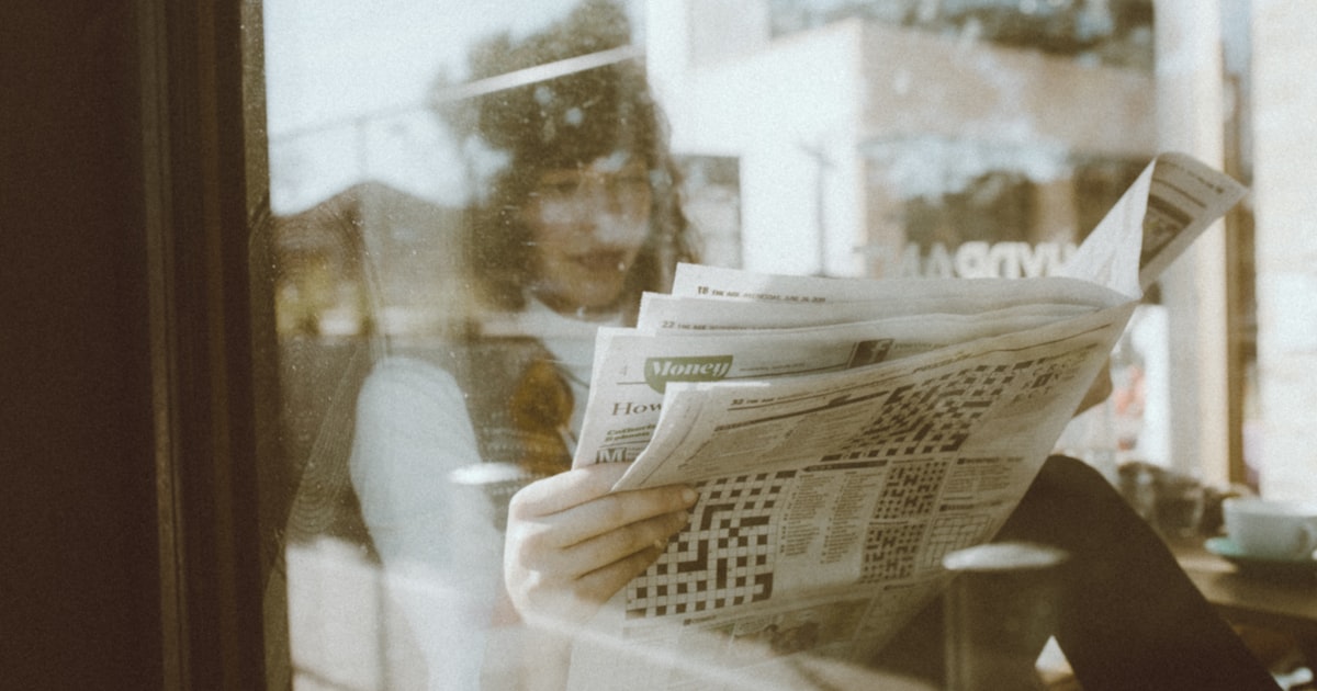 person reading newspaper inside room
