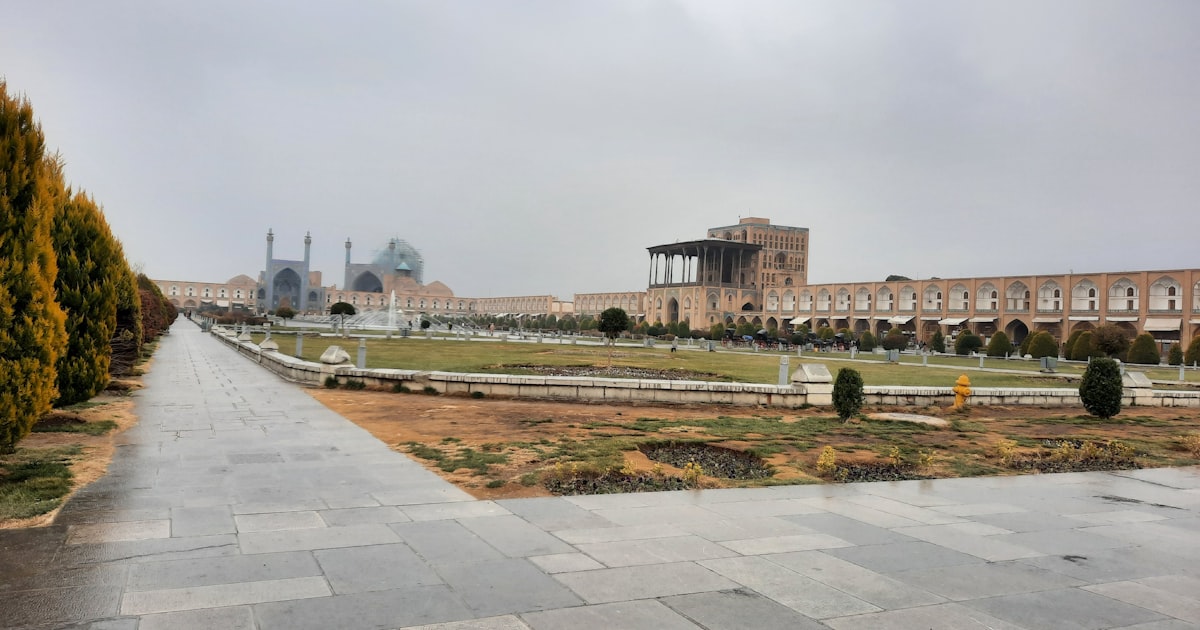 a large building sitting next to a lush green field