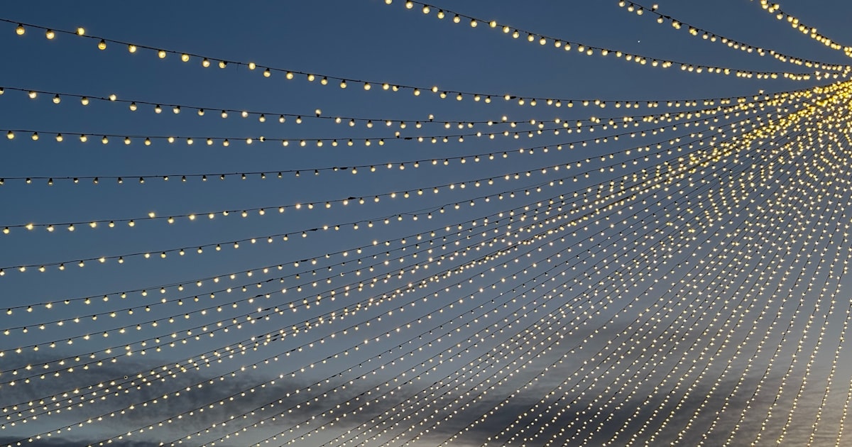 Lights illuminate the sky at dusk.