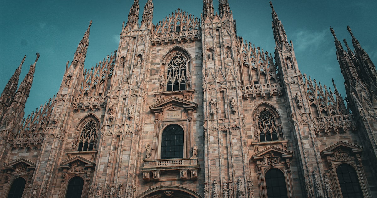 a tall cathedral with a clock on the front of it