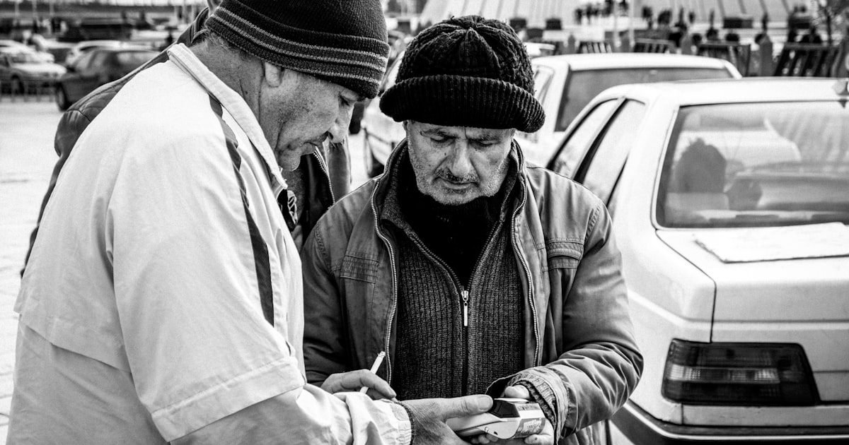 grayscale photo of man in black knit cap and white dress shirt