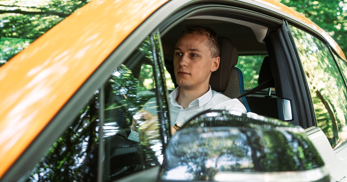 man in white dress shirt and black necktie driving car