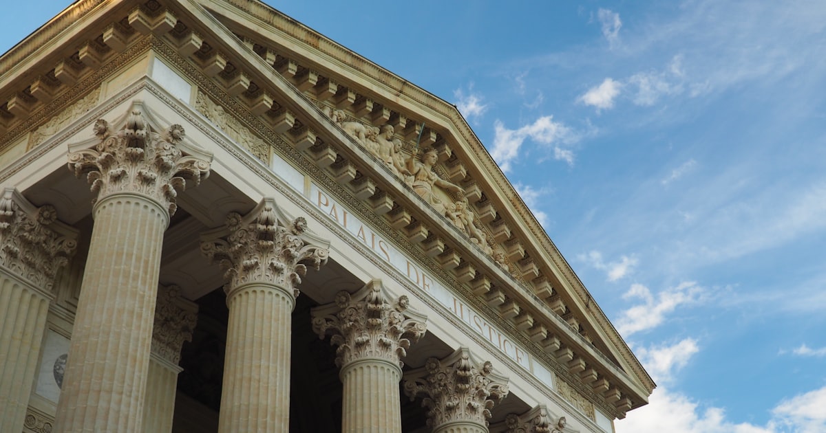 a tall building with columns and a sky background
