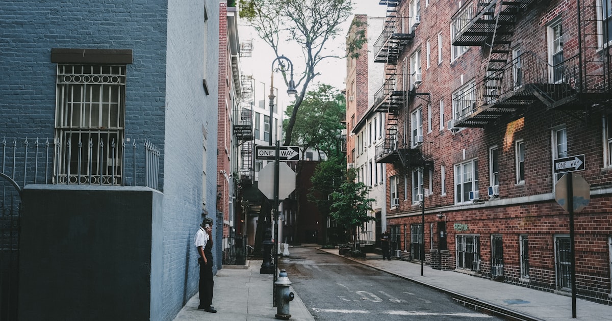 a man standing on a sidewalk next to a building