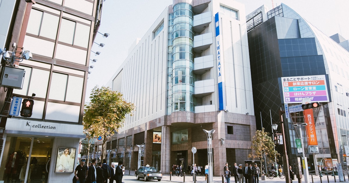 a group of people standing outside of a tall building