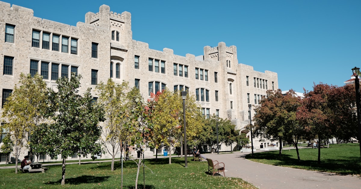 Large stone building with trees and a path