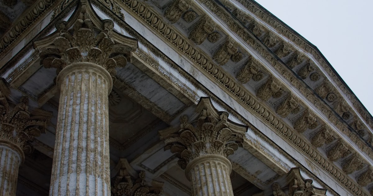 a close up of a building with columns and a clock