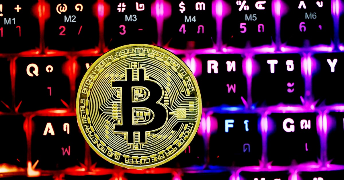 a bitcoin sitting on top of a computer keyboard