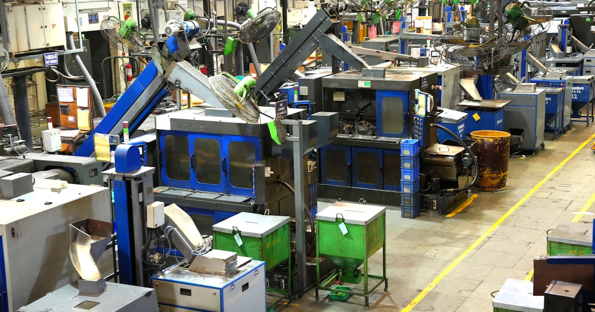 Industrial factory floor with machinery and yellow lines.