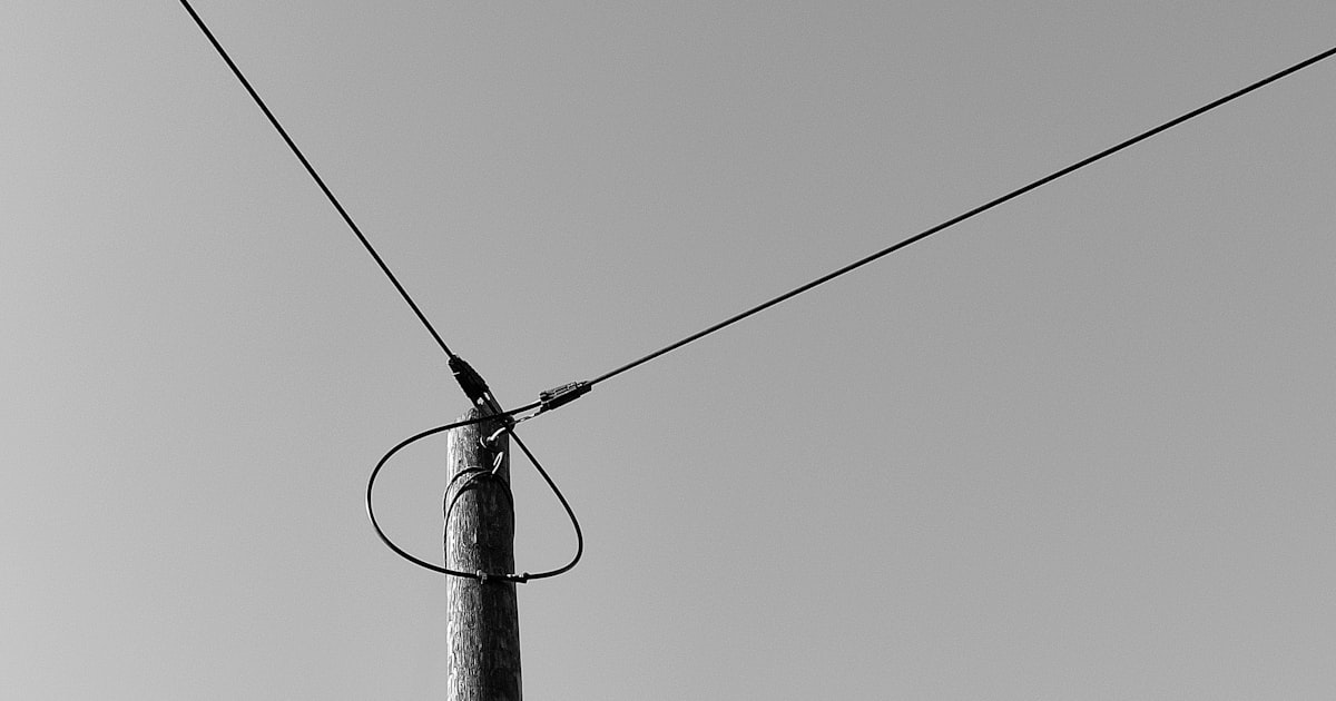 black electric post under gray sky