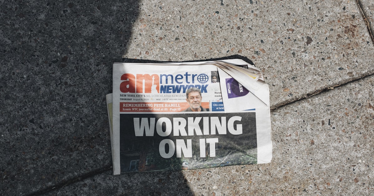 a newspaper laying on the ground next to a bag