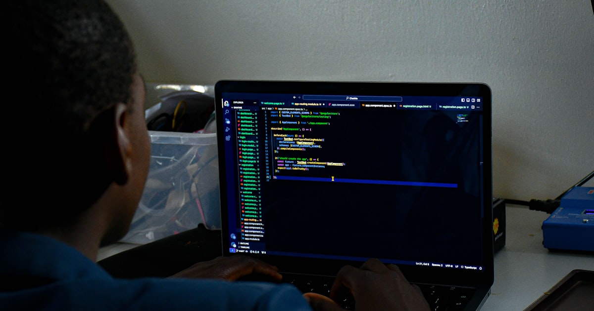 a man sitting in front of a laptop computer