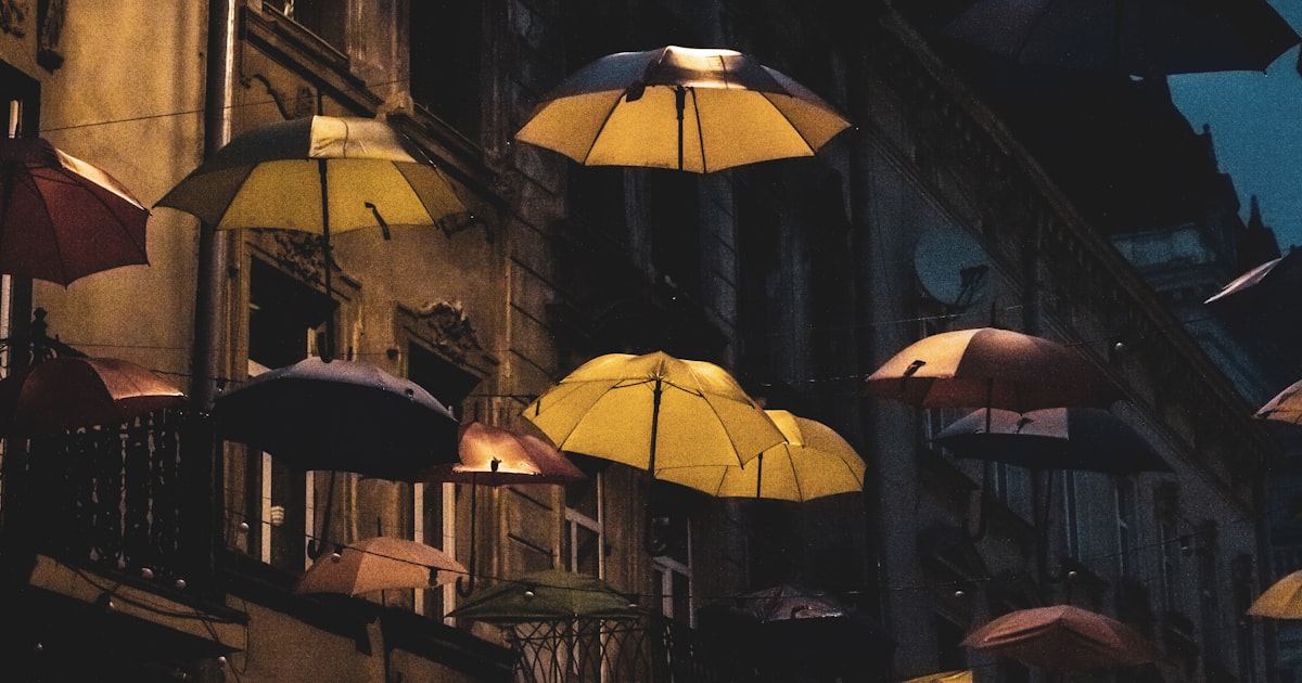 a bunch of umbrellas that are hanging from a building