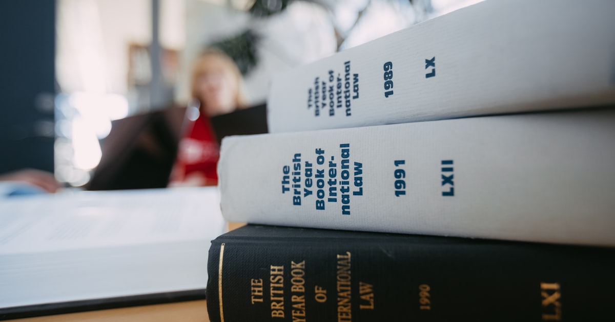 Legal books are stacked on a desk.