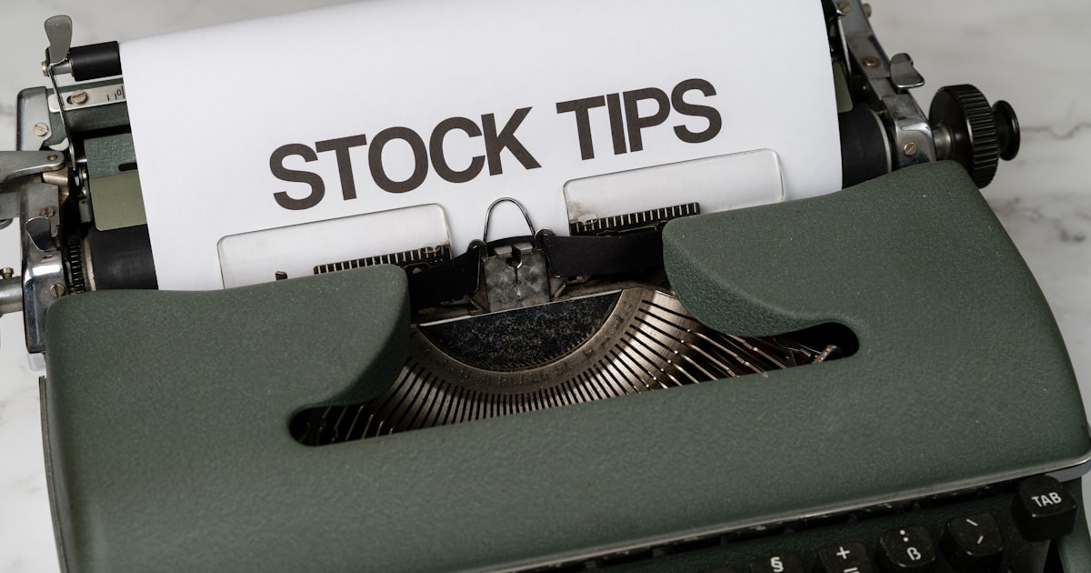 a close up of an old fashioned typewriter with a paper that reads stock tips