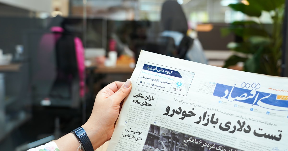 a person holding up a newspaper in their hand