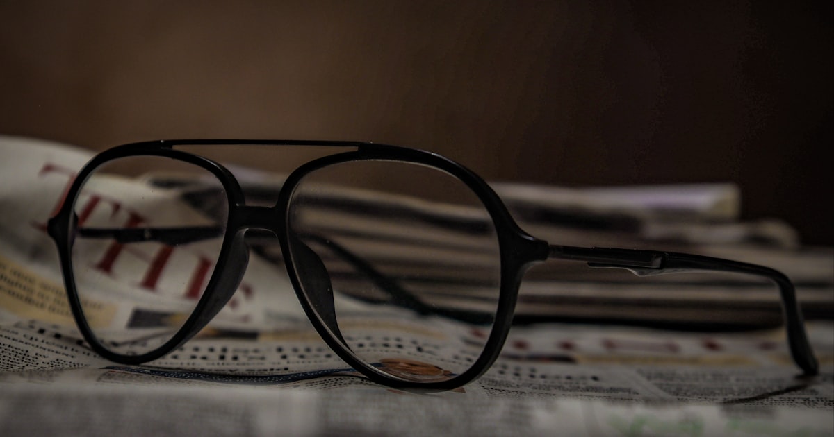 black framed eyeglasses on white printer paper