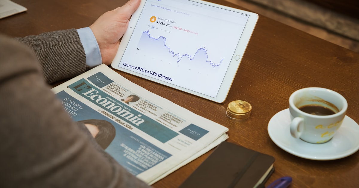 a person sitting at a table with a tablet and a cup of coffee