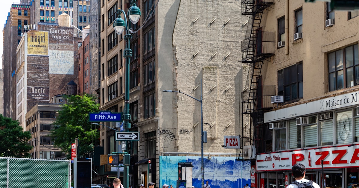 City street with buildings and people walking.