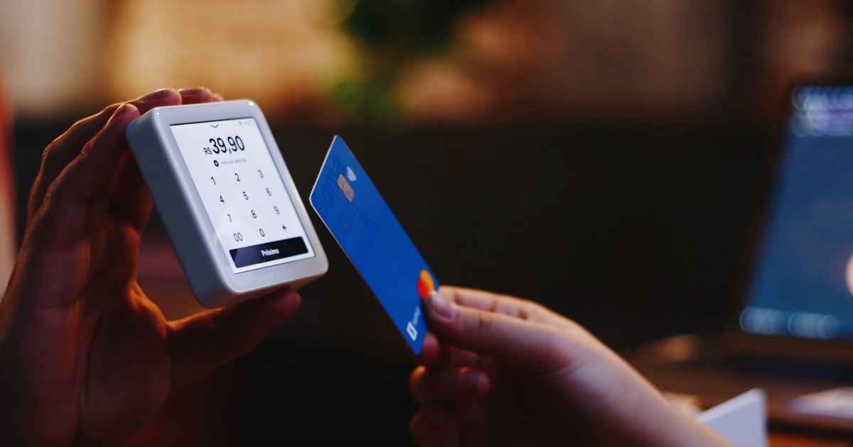 a person holding a credit card and a cell phone