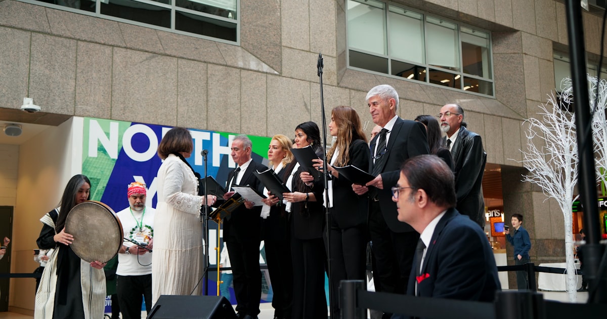 A choir performs outdoors in front of a building.
