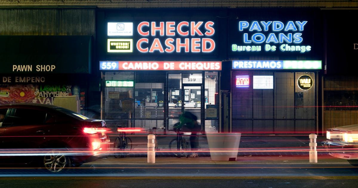 Neon signs for check cashing and payday loans at night