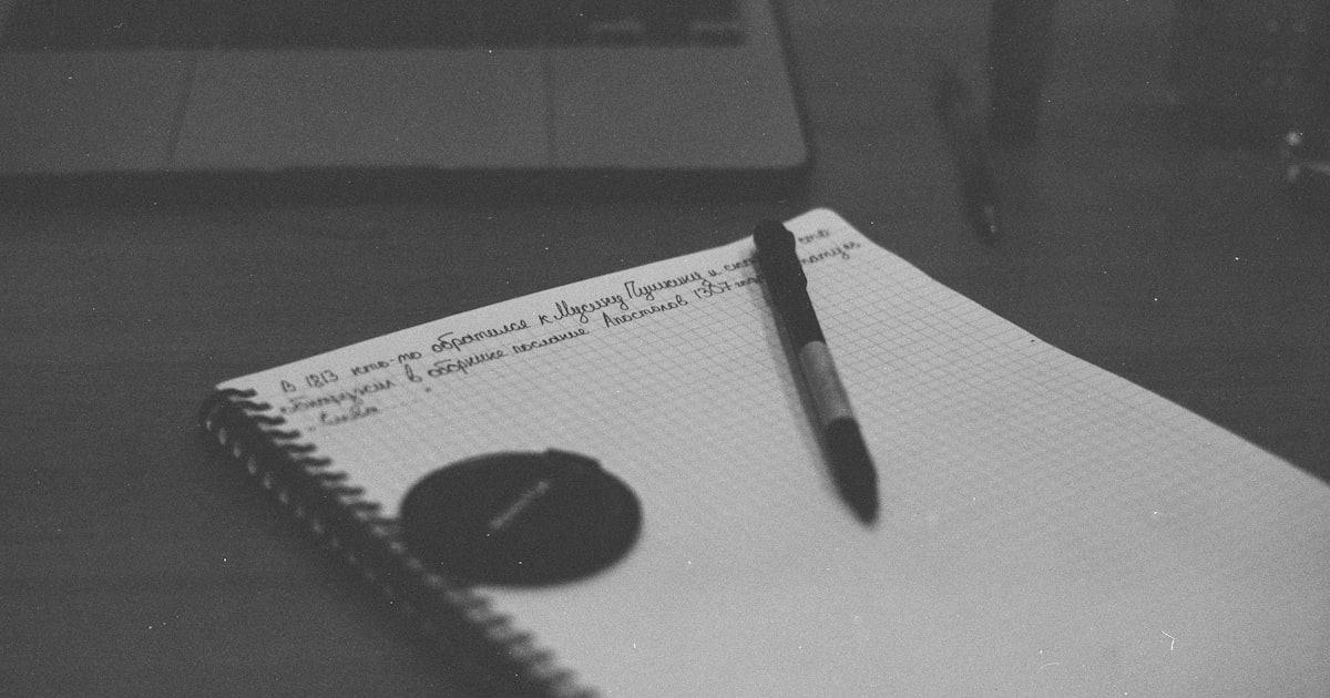 a notebook with a pen sitting on top of it