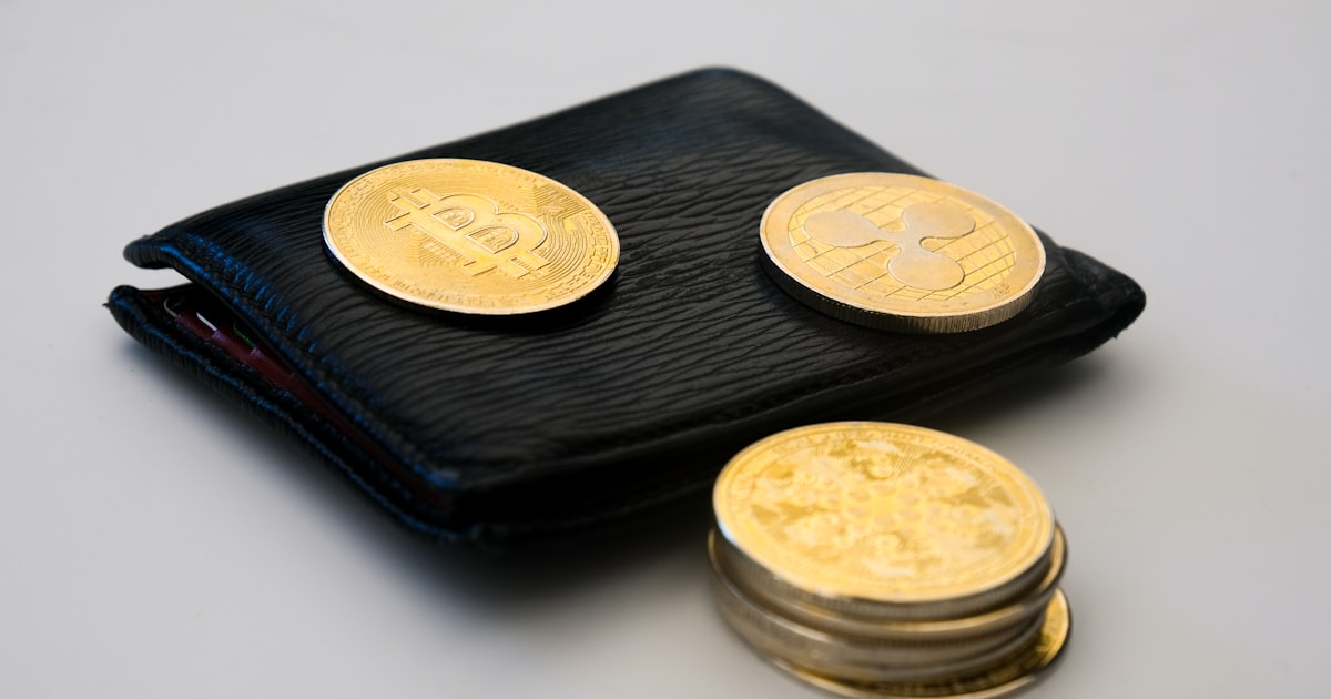 a wallet with three gold coins sitting on top of it