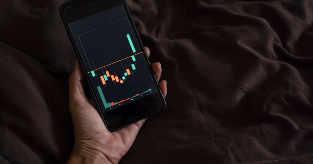 a person holding a cell phone with a chart on the screen