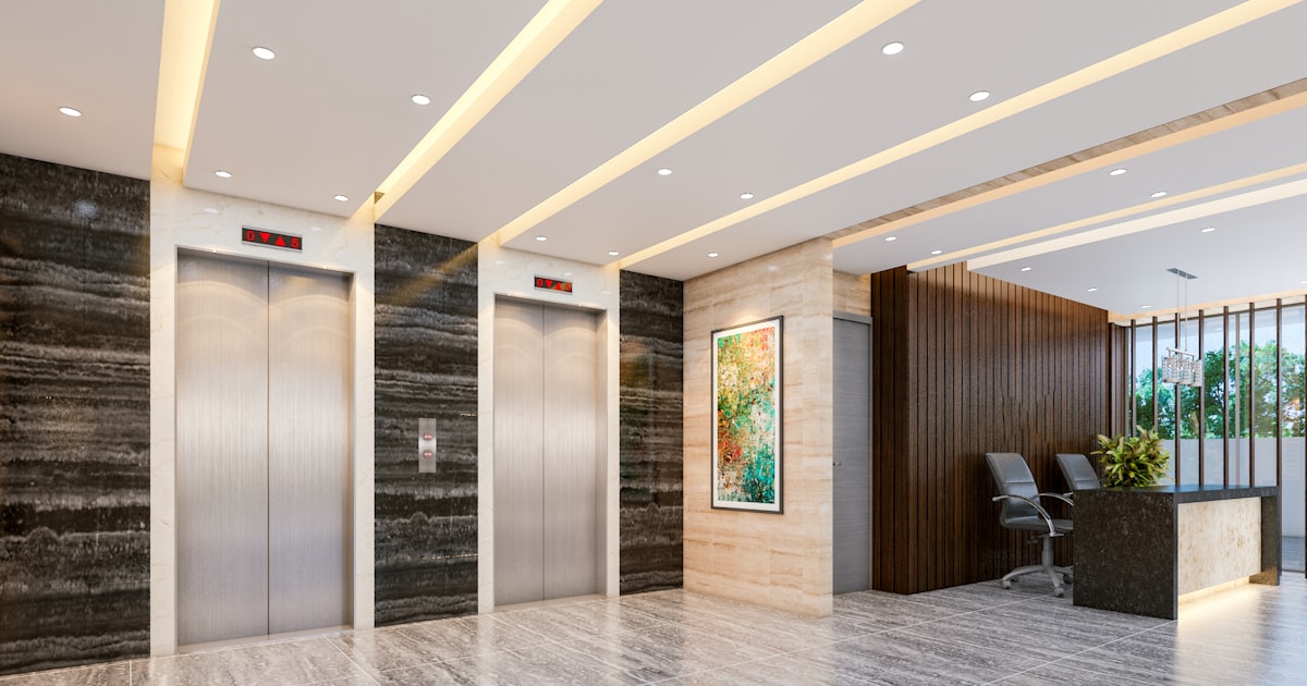 Modern lobby with elevators and reception desk.