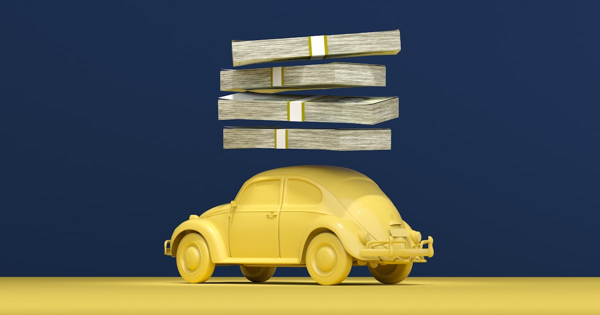 a yellow car with stacks of money on top of it