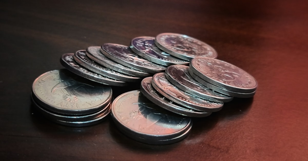 silver round coins on brown wooden table