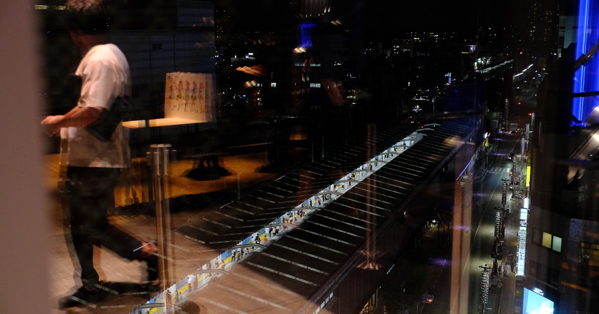 a man riding a skateboard next to a tall building