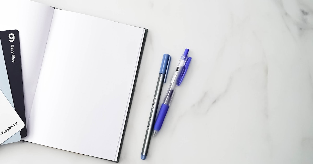a group of pens on a white surface
