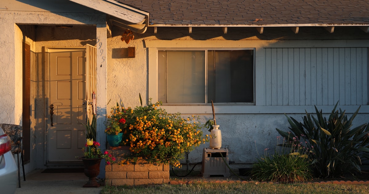 A simple house lit by the setting sun.